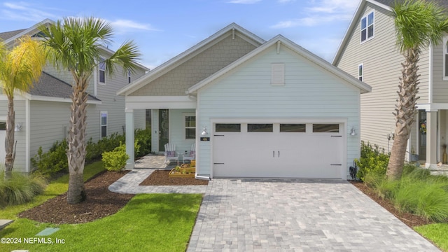 view of front of house with a garage, a porch, and decorative driveway