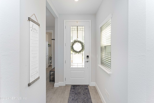 foyer entrance featuring light wood-style floors and baseboards