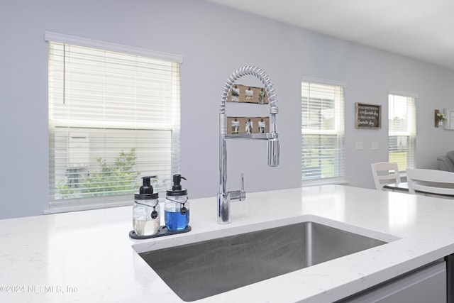 kitchen featuring a sink and light stone countertops