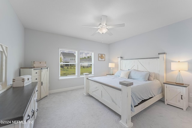 bedroom featuring baseboards, a ceiling fan, and light colored carpet