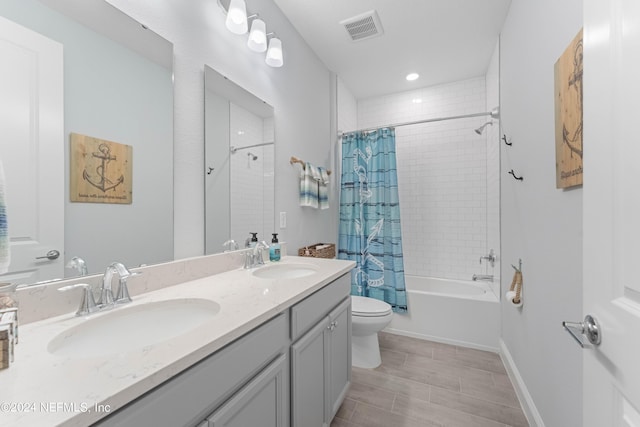 bathroom featuring toilet, shower / tub combo, visible vents, and a sink