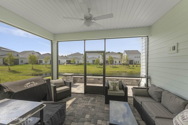 sunroom / solarium featuring wooden ceiling, a water view, a residential view, and a ceiling fan