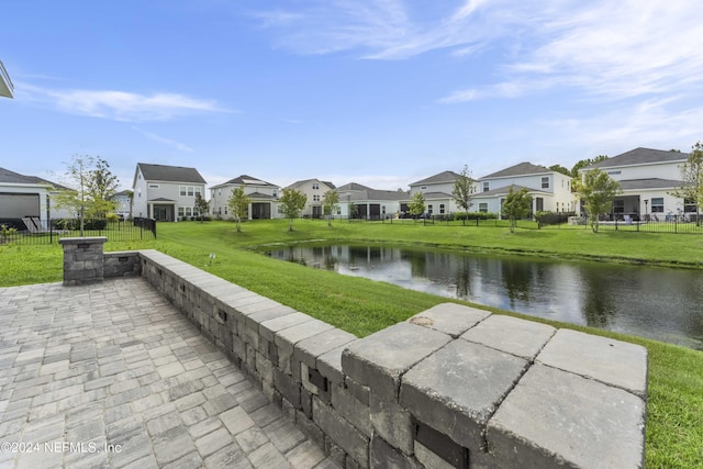 surrounding community with a residential view, a water view, fence, and a lawn