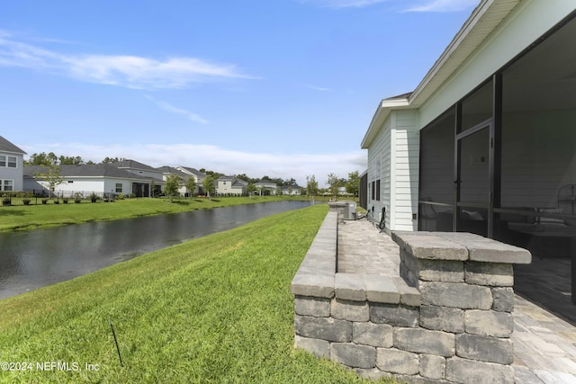 view of yard with a patio area, a water view, and a residential view