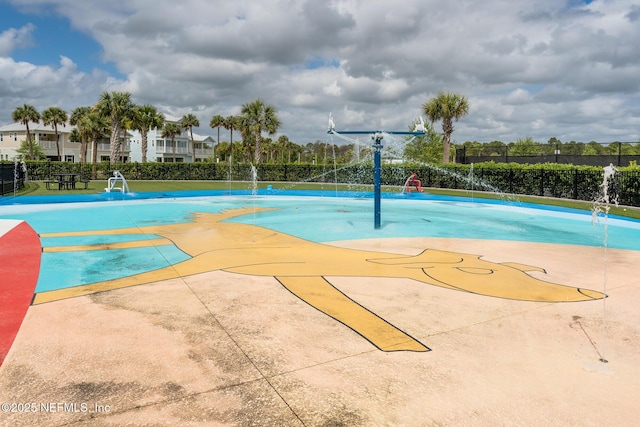 view of basketball court with a pool and fence