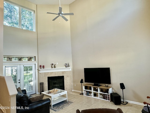 tiled living room featuring french doors, ceiling fan, and a high ceiling