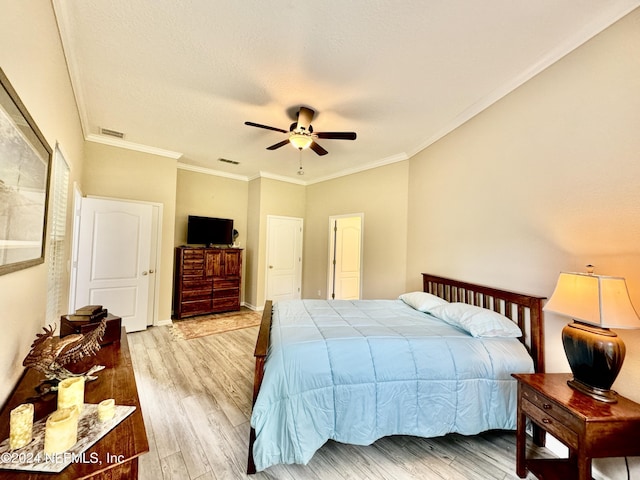 bedroom with ceiling fan, light hardwood / wood-style floors, and ornamental molding