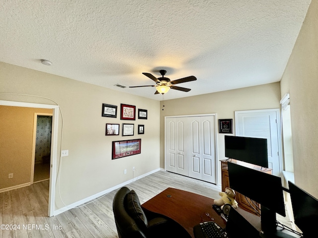 office area featuring a textured ceiling, light hardwood / wood-style floors, and ceiling fan