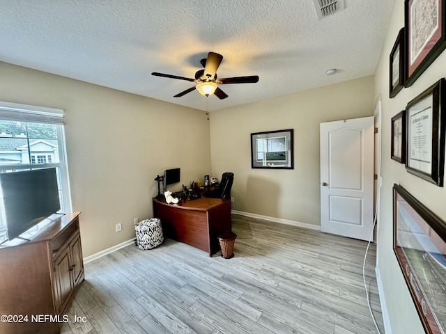 home office featuring ceiling fan, a textured ceiling, and light wood-type flooring