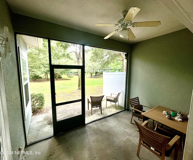 doorway with a textured ceiling, concrete floors, and ceiling fan