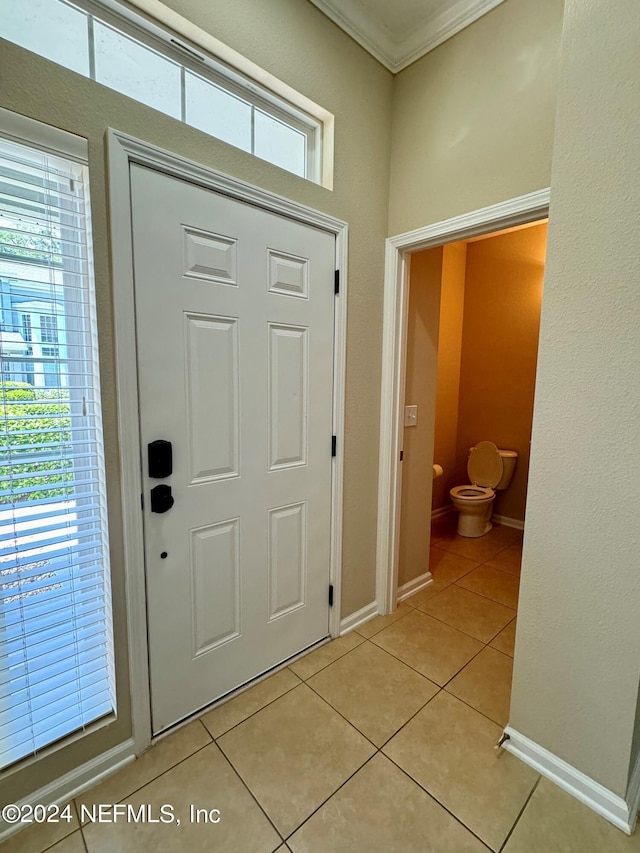 foyer entrance featuring plenty of natural light, light tile patterned floors, and ornamental molding