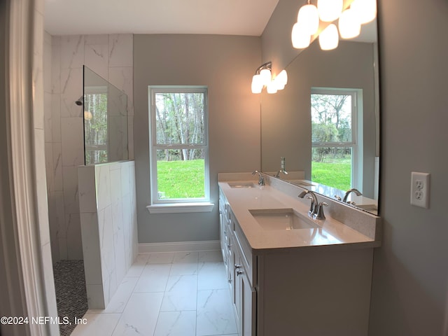 bathroom with tile floors, tiled shower, and double vanity