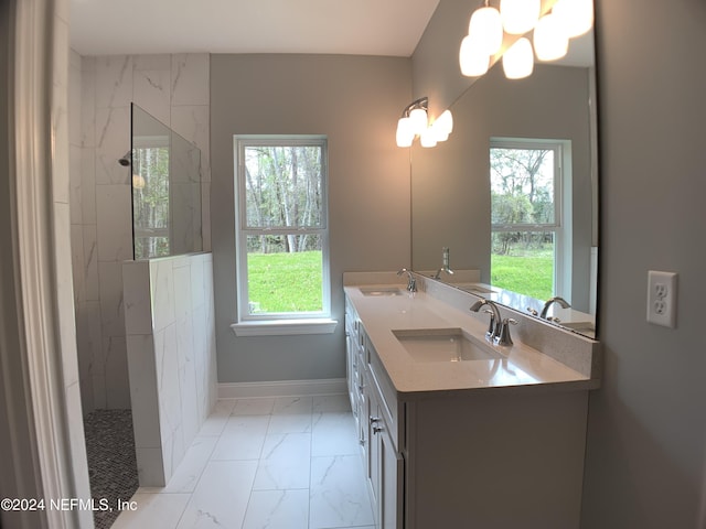 bathroom with vanity, a chandelier, and a tile shower