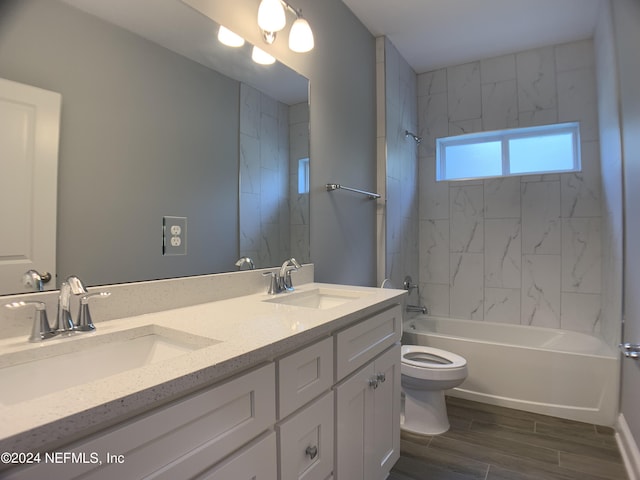 full bathroom featuring tiled shower / bath combo, vanity, and toilet