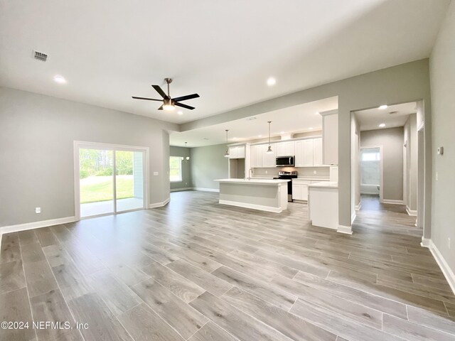 unfurnished living room with light hardwood / wood-style floors and ceiling fan