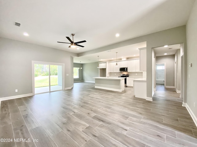 unfurnished living room with ceiling fan and light hardwood / wood-style floors