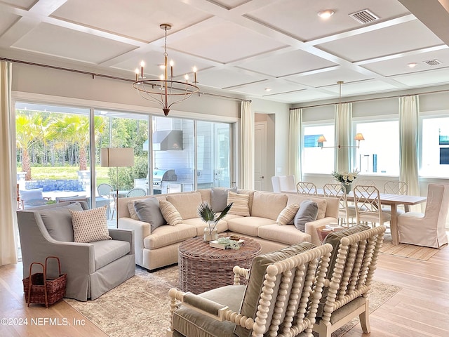 sunroom with beam ceiling, plenty of natural light, coffered ceiling, and an inviting chandelier