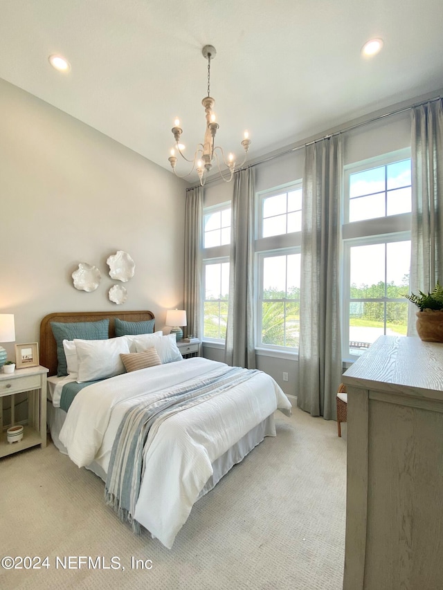 carpeted bedroom featuring a notable chandelier