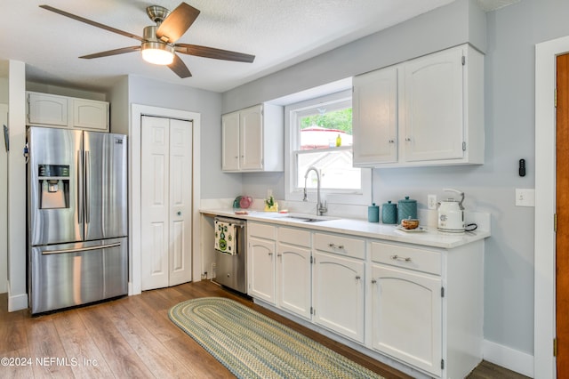 kitchen featuring white cabinets, light hardwood / wood-style floors, sink, and appliances with stainless steel finishes