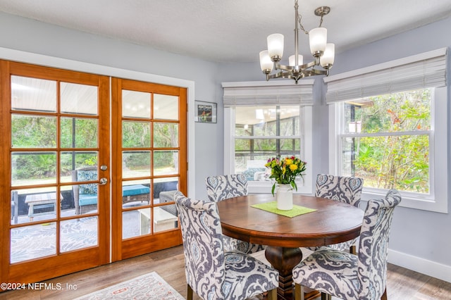 dining area featuring french doors, an inviting chandelier, and light hardwood / wood-style flooring