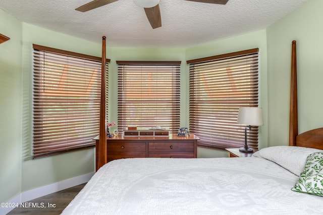 bedroom featuring ceiling fan, dark hardwood / wood-style flooring, and a textured ceiling