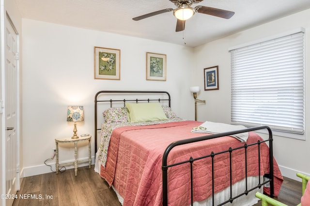 bedroom with dark hardwood / wood-style floors and ceiling fan