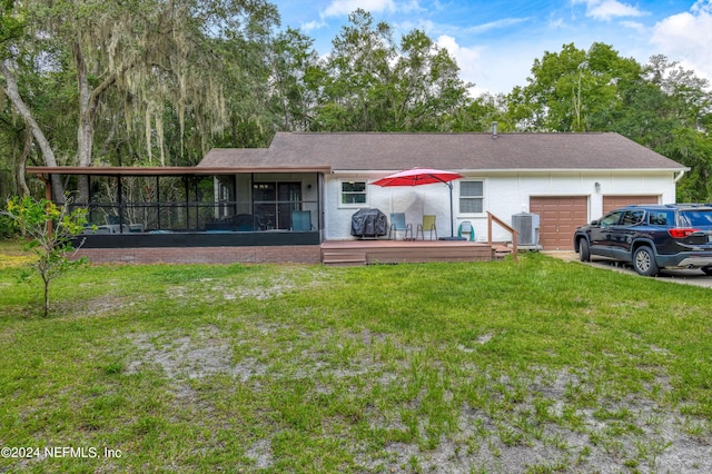 single story home with a sunroom, a deck, cooling unit, a front lawn, and a garage