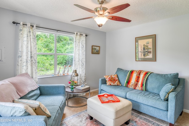 carpeted living room featuring ceiling fan and a textured ceiling