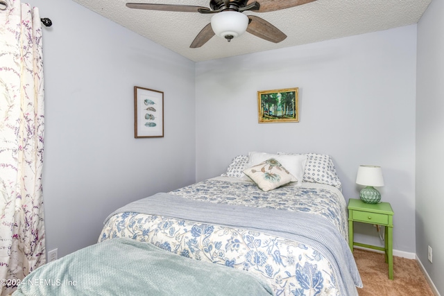 carpeted bedroom featuring ceiling fan and a textured ceiling