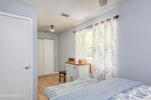 carpeted bedroom with a textured ceiling, a closet, and ceiling fan