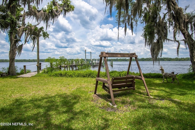 view of home's community with a lawn, a boat dock, and a water view