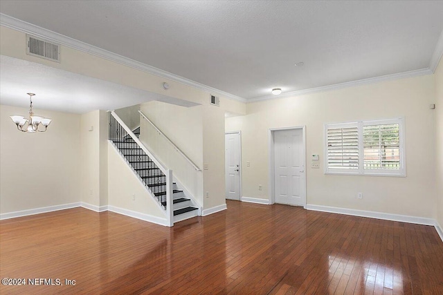 spare room featuring crown molding, dark hardwood / wood-style floors, and a notable chandelier