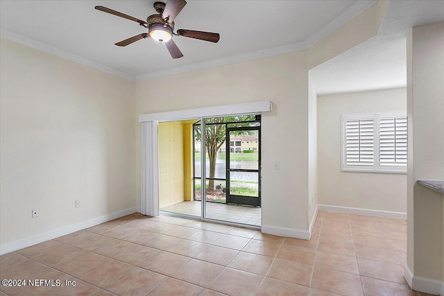 tiled empty room featuring ornamental molding and ceiling fan