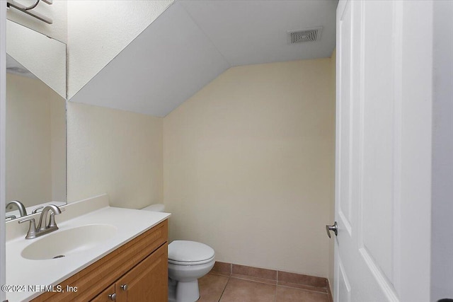 bathroom with vanity, tile patterned floors, toilet, and lofted ceiling