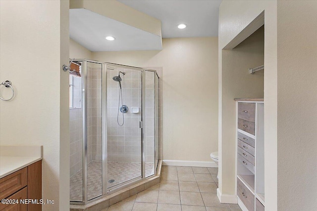 bathroom featuring tile patterned floors, toilet, an enclosed shower, and vanity