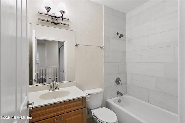 full bathroom featuring vanity, tiled shower / bath, and toilet