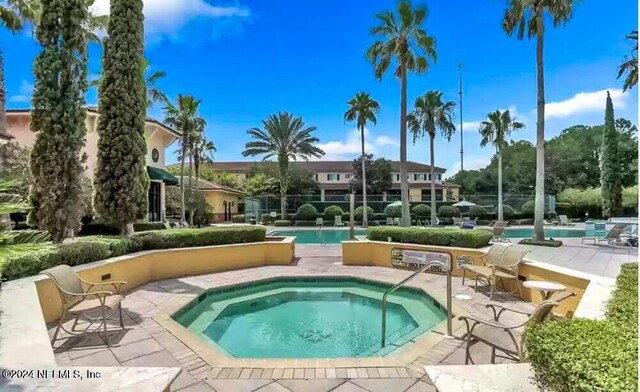 view of swimming pool featuring a hot tub and a patio