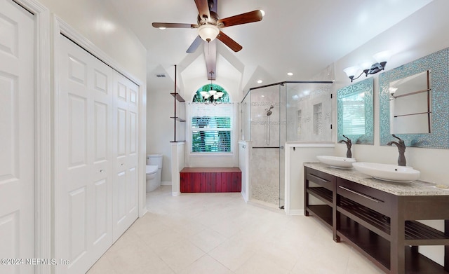 bathroom with ceiling fan, vanity, a shower with shower door, and toilet