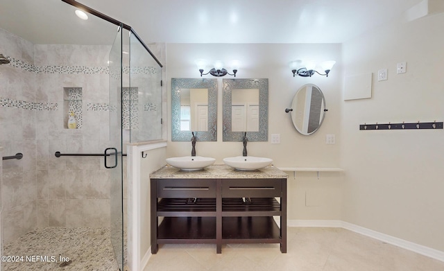 bathroom with an enclosed shower, vanity, and tile patterned flooring