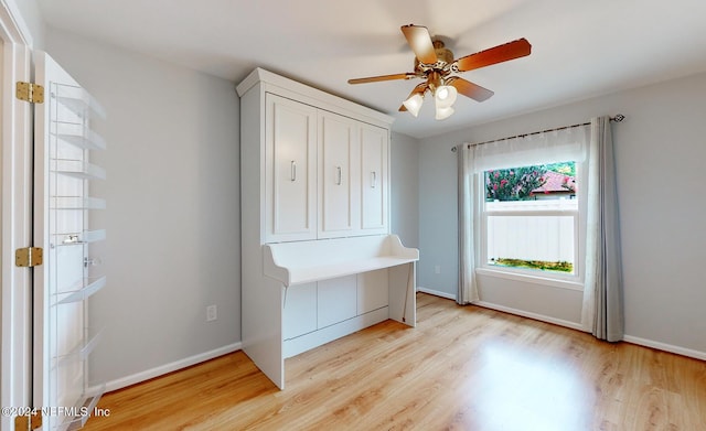 unfurnished office with ceiling fan and light wood-type flooring