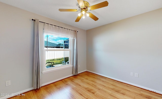 empty room with ceiling fan and light hardwood / wood-style flooring