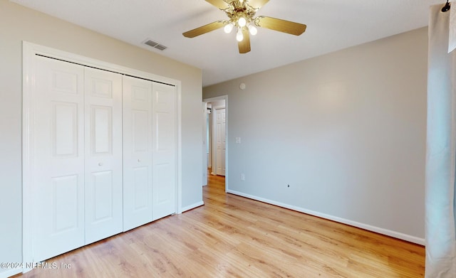 unfurnished bedroom featuring ceiling fan, light hardwood / wood-style floors, and a closet