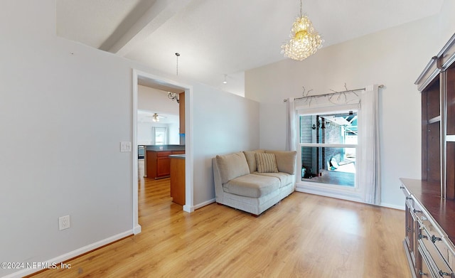 living room featuring a notable chandelier, light hardwood / wood-style floors, and plenty of natural light