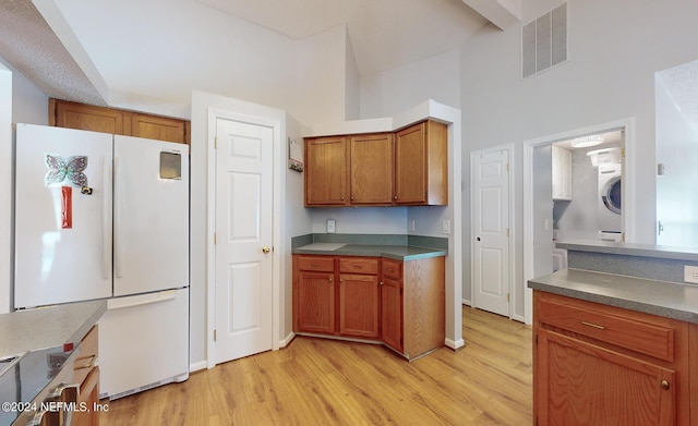 kitchen featuring washer / dryer, white fridge, and light hardwood / wood-style floors