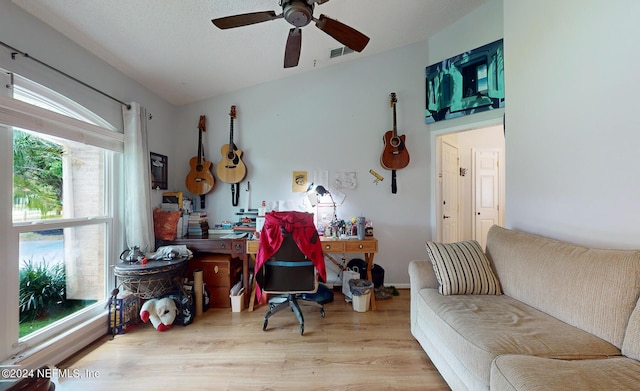 living room featuring ceiling fan, light hardwood / wood-style flooring, and vaulted ceiling