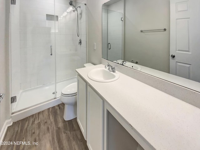 bathroom with toilet, vanity, hardwood / wood-style floors, and walk in shower