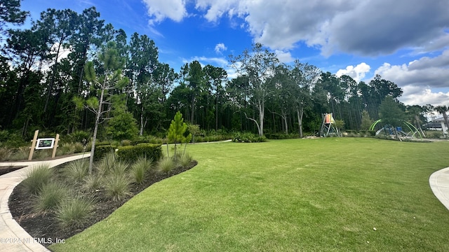 view of home's community with a playground and a yard