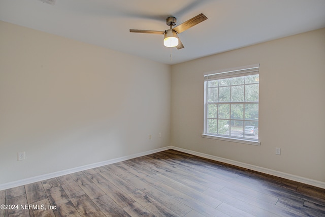 spare room with dark hardwood / wood-style floors and ceiling fan