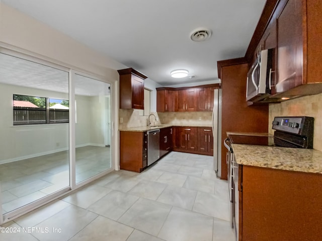 kitchen featuring light tile patterned flooring, appliances with stainless steel finishes, tasteful backsplash, and sink