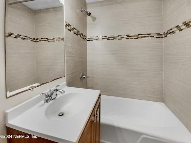 bathroom featuring a tile shower and vanity